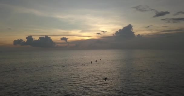 Вид с воздуха на серферов в океане на закате — стоковое видео