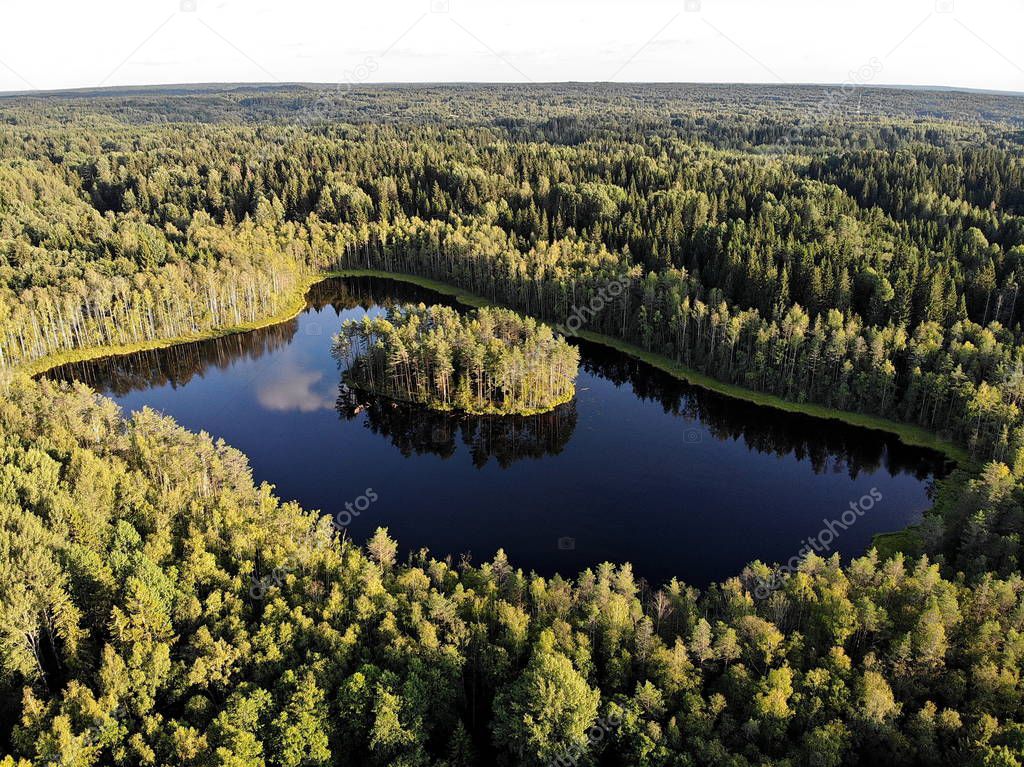  Aerial view of a lake with round island in the middle of the forest of Valday, Russia