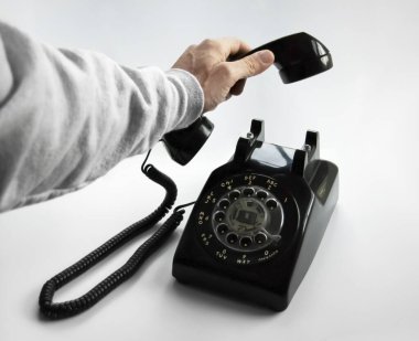 A Hand Picks Up an Old Rotary Phone clipart