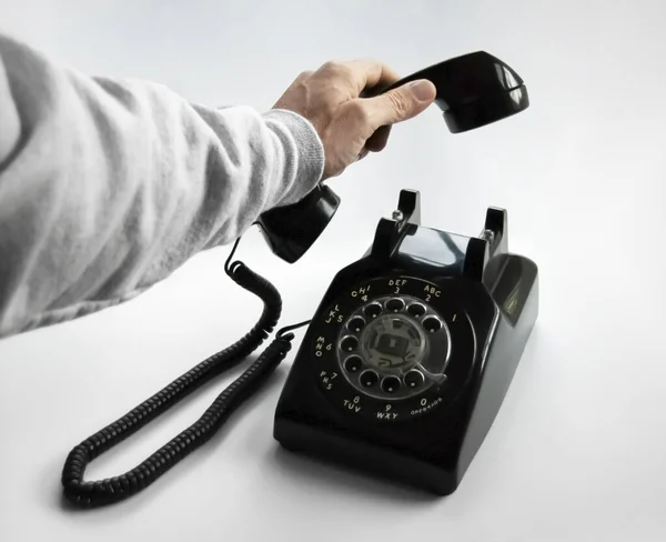 Egy kéz felvesz egy régi forgótelefont — Stock Fotó