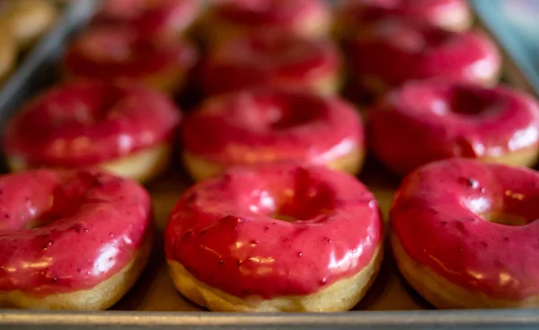 Uma bandeja cheia de belos donuts de cranberry rosa — Fotografia de Stock