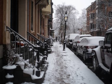 Kar fırtınasında kaldırımda yürüyen bir adam.