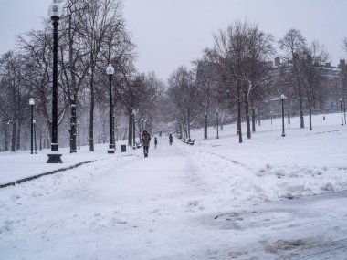 Birkaç kişi kışın bir yolda yürür.