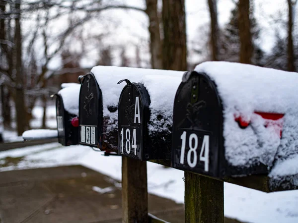 Снег покрывает некоторые почтовые ящики зимой — стоковое фото