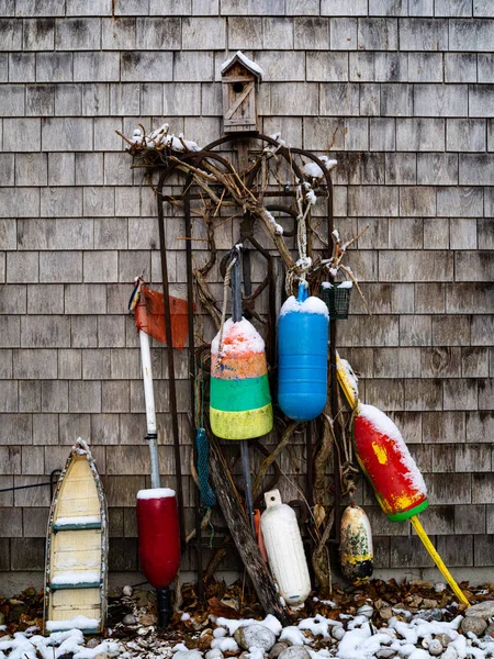 As bóias e uma casa de pássaros se apoiam contra uma parede no inverno — Fotografia de Stock