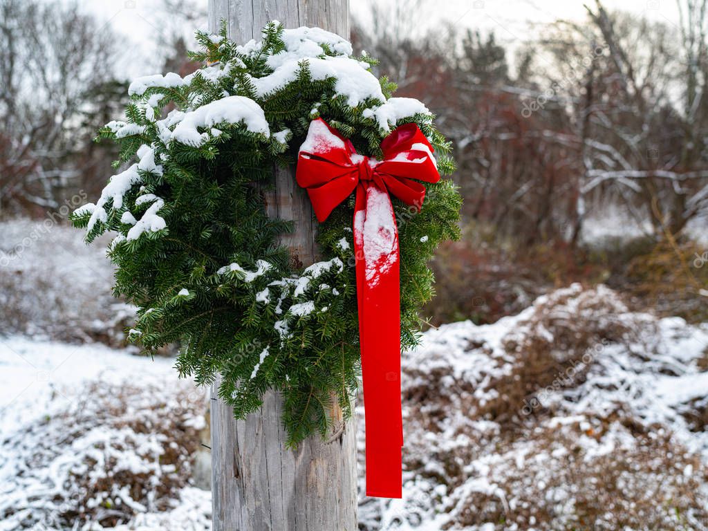 A Simple Green Pine Wreath With A Long Red Bow