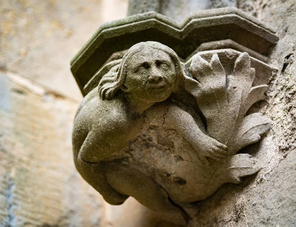 Une femme sculptée à la base d'une colonne de pierre — Photo