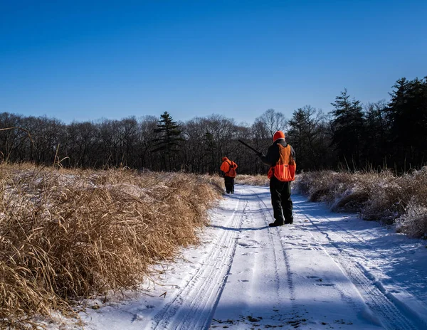 Un cazador de aves mira a su compañero en invierno — Foto de Stock