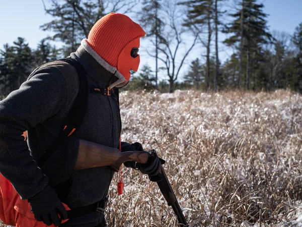 Un cazador de aves usando una máscara y recargando una escopeta — Foto de Stock