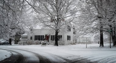 Kışın karla kaplı bir New England evi.