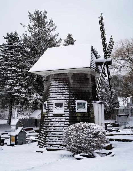 Um moinho de vento em miniatura coberto de neve em um mini campo de golfe — Fotografia de Stock