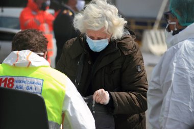 Salerno, Sa, İtalya - Nisan 06: 2020: Limanda karaya çıkan İtalyan vatandaşlar, sağlık yetkilileri tarafından sağlık kontrollerine tabi tutuluyor. Geri döndüklerinde gönüllü karantinaya alınacaklar .