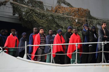 Salerno, İtalya - Kasım 05.2017: Denizde iyileşen bazı mülteciler, kendilerini deniz yolculuğunun soğuğundan korumak için battaniyelerle geminin güvertesinde beklediler.