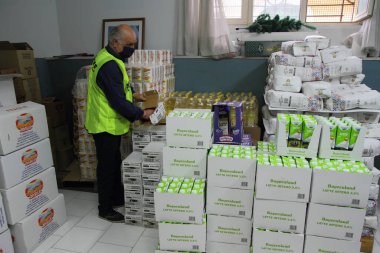 Pagani, Sa, İtalya - 19 Mayıs 2020: Bölgedeki caritas ambarında çalışan bir gönüllü para ve iş sıkıntısı çeken ailelere dağıtılmak üzere kurumuş baklagil paketleri açıyor.