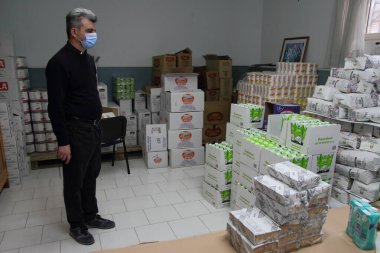Pagani, Sa, Italy- 19 Mayıs 2020: Depodaki kilise rahibi Enzo paraya ihtiyacı olan ailelere yiyecek ve içecek sağlayan ambarlardan sorumlu..