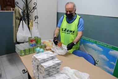 Pagani, Sa, Italy- 19 Mayıs 2020: Cemaatin karitalarından bir gönüllü, yiyecek yardımına ihtiyacı olan aileler için yiyecek ve içecek paketleri hazırlarken,.