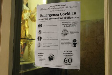 Pagani, Sa, İtalya - 19 Mayıs 2020: Carmel Hanımefendimizin Sığınağı 'nın girişine yerleştirilen işaret, inananlara covid-19 sırasında uygulanan önleme normlarını ve erişim kurallarını göstermektedir..