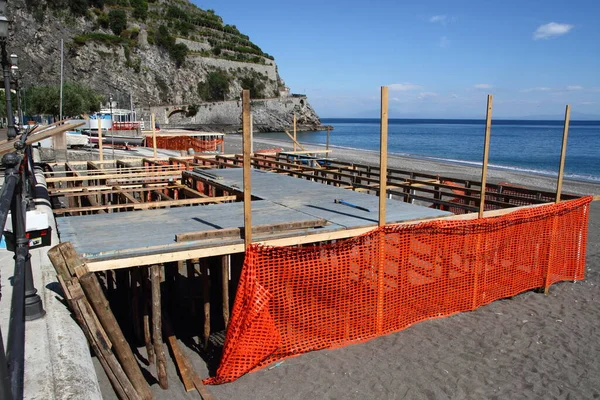 Minori, Sa, İtalya - 21 Mayıs 2020: Yeni yaz sezonu için plajların kabinlerini inşa etmek için deniz kenarında ahşap tahtalar montajı . 