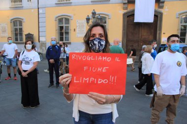 Nocera Inferiore, Sa, İtalya - 23 Mayıs 2020: Karteli ile birlikte Sarno Nehri 'nin en kirli nehirlerinin korunması için Aquamunda derneği tarafından düzenlenen flash mob' a katılan bir kadın.