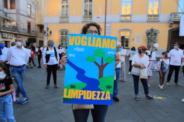 Nocera Inferiore, Sa, İtalya - 23 Mayıs 2020: Maskeli ve karteli olan bir kadın, Sarno Nehri 'nin korunması için düzenlenen ve en kirli nehirlerden biri olarak kabul edilen çeteye katıldı. .