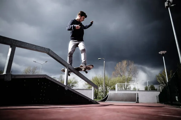 Skater robi trick boardslide na szynie w skateparku — Zdjęcie stockowe