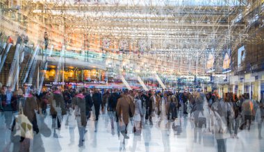 Multiple exposure image of lots of people walking and waiting for boarding in the Waterloo train station. Commuting rush hours concept, modern life. clipart