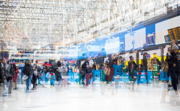 Flera exponering bild av massor av människor går och väntar på boarding på Waterloo järnvägsstationen. Pendling rusningstid koncept, moderna liv. — Stockfoto
