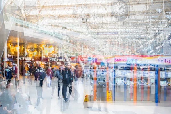 Imagen de exposición múltiple de muchas personas caminando y esperando el embarque en la estación de tren de Waterloo. Conmutar el concepto de horas punta, la vida moderna . — Foto de Stock