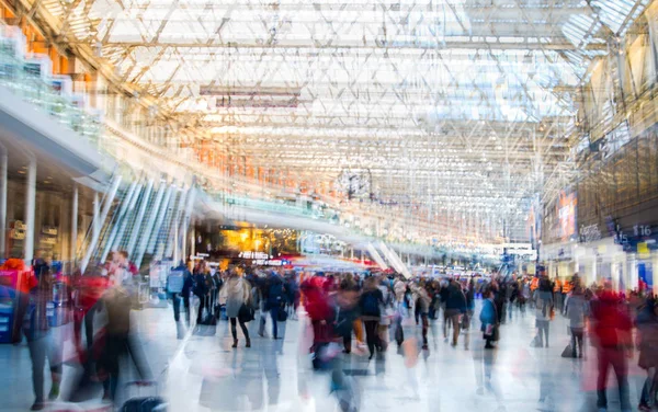 Imagen de exposición múltiple de muchas personas caminando y esperando el embarque en la estación de tren de Waterloo. Conmutar el concepto de horas punta, la vida moderna . — Foto de Stock