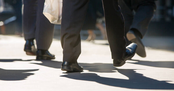 Feet of walking business people in the City of London. Busy modern life concept.