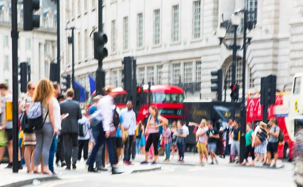 Piccadilly circus med massor av människor, turister och Londonbor passerar korsningen. London, Storbritannien — Stockfoto