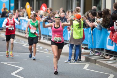 Halk tarafından tezahürat mutlu maraton koşucusu. Hayır para toplamak.