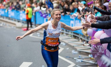 Halk tarafından tezahürat mutlu maraton koşucusu. Hayır para toplamak.