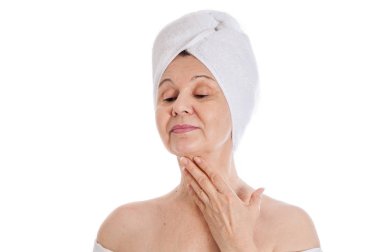 Spa ve güzellik kavramı. Başında beyaz havlu ile iyi görünümlü kadın yaşlı