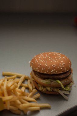 Hamburger ve patates kızartması masada.