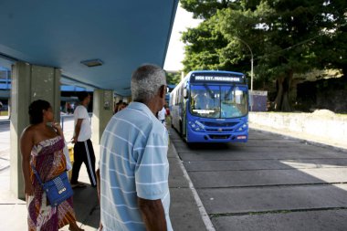 elderly man in public transportation in Salvador clipart