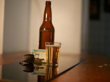 Salvador, Bahia / Brezilya - 29 Haziran 2015: Araç sürücülerinin içki tüketimini sembolize eden sürücü ehliyeti ve araç anahtarının yanındaki bar masasındaki bira şişesi. 