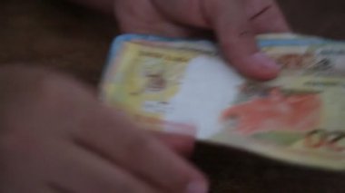 Salvador, Bahia / Brezilya - 28 Mart 2020: Brezilya 'da kullanılan para birimi olan Reais banknotları kadının ellerinde..