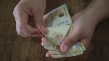 Salvador, Bahia / Brezilya - 28 Mart 2020: Brezilya 'da kullanılan para birimi olan Reais banknotları kadının ellerinde..