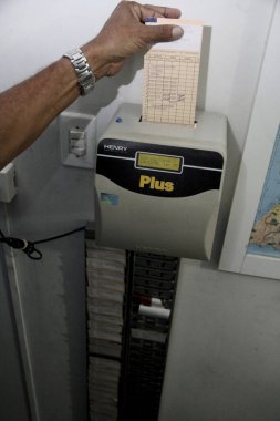 Salvador, Bahia / Brezilya - Kasım 12, 2013: işçi mesai kartını kullanarak iş yerinde kayıt yaptırırken görülüyor. * * * Yerel altyazı * *