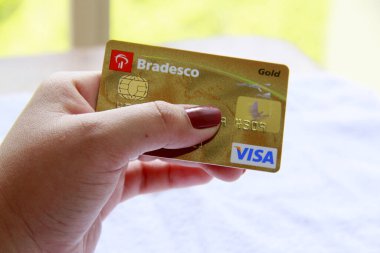 Salvador, Bahia / Brezilya - 10 Kasım 2013: Bradesco Visa kredi kartını tutan kadın
