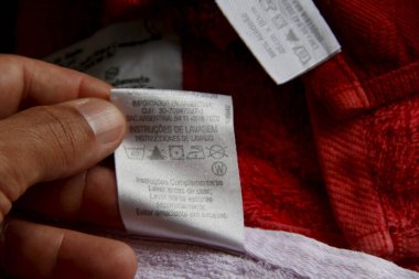 Salvador, Bahia / Brezilya - 19 Nisan 2013: Yıkama ve kurutma bilgileri içeren kıyafet etiketi. * * * Yerel altyazı * *