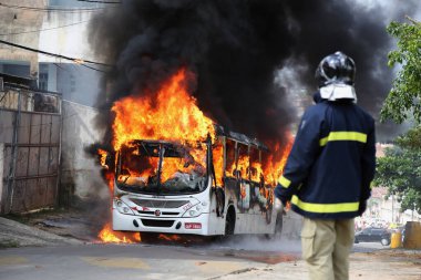 Salvador, Bahia / Brezilya - 23 Ocak 2015: İtfaiyeci Mata Escura civarında bir toplu taşıma otobüsünün yangınını takip ediyor. Yangın, olay yerinde uyuşturucu satışı kontrolü için kavga eden haydutlar tarafından çıkarıldı. * * * Yerel altyazı * *