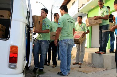 Eunapolis, Bahia / Brezilya - 5 Ekim 2008: Eunapolis şehrinde seçimler için Brezilya elektronik oy sandığı taşıyan Bölgesel Seçim Mahkemesi çalışanı