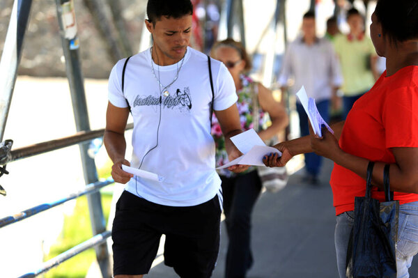salvador, bahia / brazil - november 12, 2015: person is seen distributing advertising leaflets facing the city of Salvador. The practice is known as leafleting. *** Local Caption ***