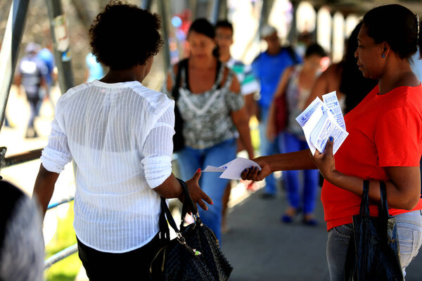 salvador, bahia / brazil - november 12, 2015: person is seen distributing advertising leaflets facing the city of Salvador. The practice is known as leafleting. *** Local Caption ***