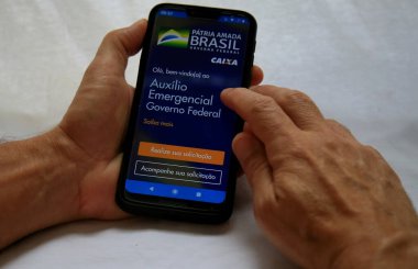 Salvador, Bahia / Brezilya - 18 Mayıs 2020: Corona Virüsü 'nden etkilenen vatandaşlar için Brezilya Federal Hükümeti acil yardım başvurusuna eriştiği görüldü.. 