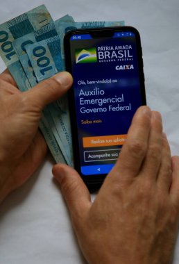 Salvador, Bahia / Brezilya - 18 Mayıs 2020: Corona Virüsü 'nden etkilenen vatandaşlar için Brezilya Federal Hükümeti acil yardım başvurusuna eriştiği görüldü. * * * Yerel altyazı * *