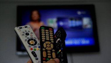 Salvador, Bahia / Brezilya - 21 Mayıs 2020: Uzaktan kumanda televizyonun elinde. * * * Yerel altyazı * *