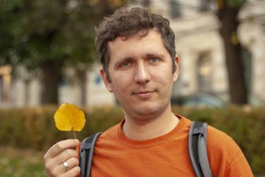 Sonbahar yapraklı genç bir adam.